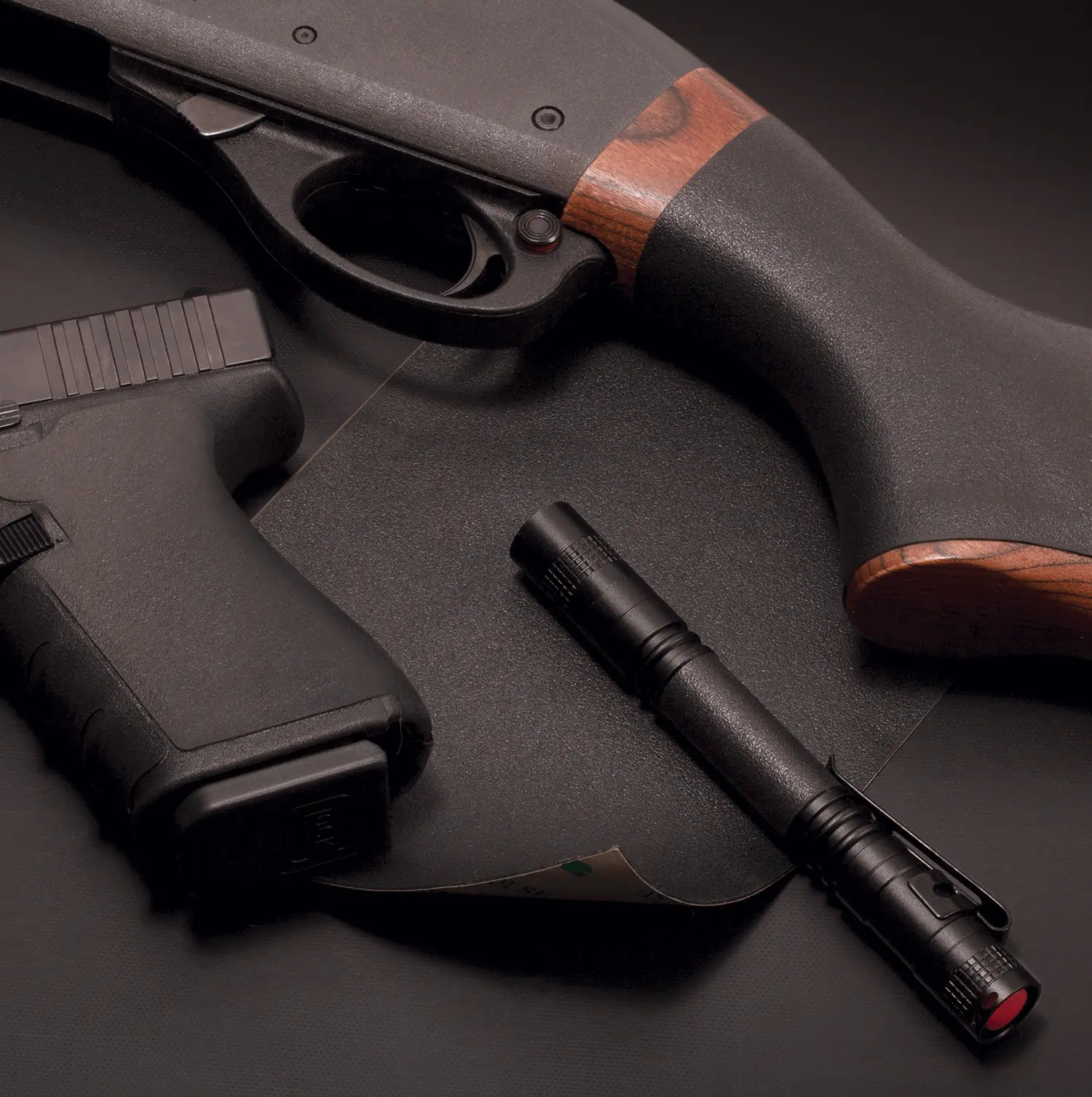 Gun with flashlight and laser sight on black background.