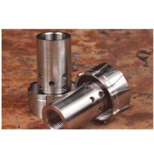Close-up of metallic firearm components with threaded and drilled sections.